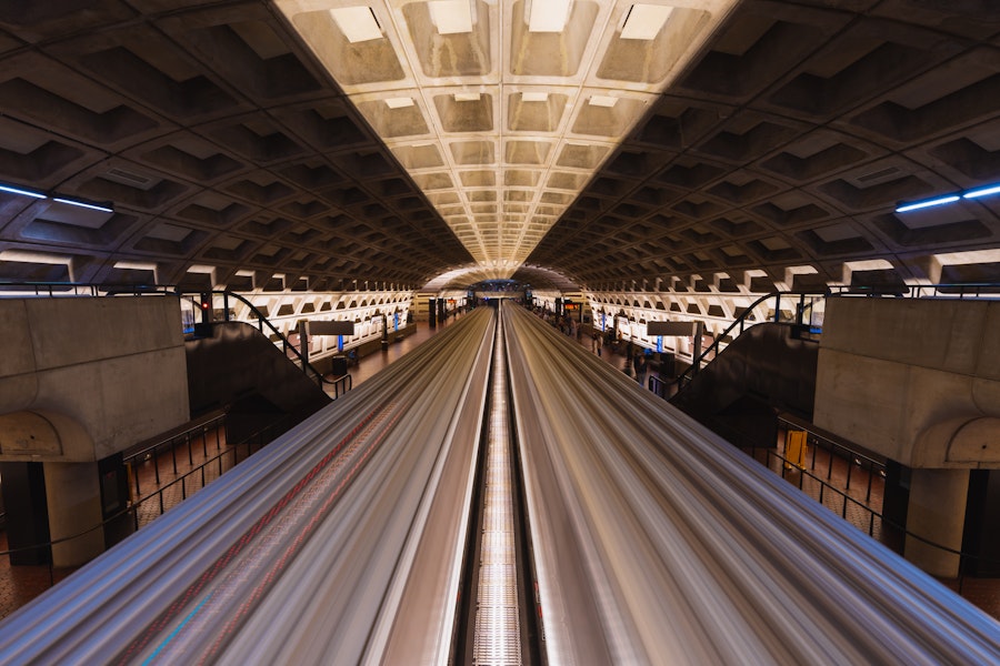 A long-exposure shot captures the motion of a train at Metro Center station in Washington, DC.