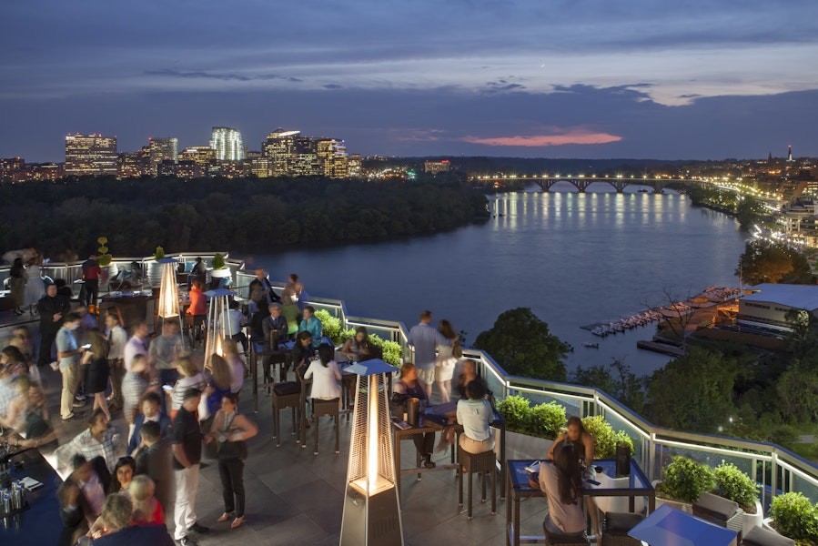 Looking out over the Potomac River onto Arlington with people looking on the rooftop