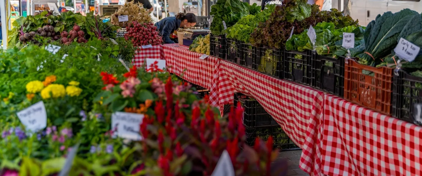Tables filled with colorful produce at a farmer's market. 