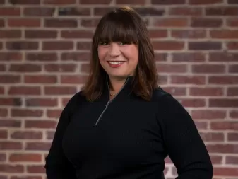 A woman smiles for a professional headshot. 